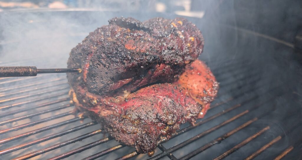 Meat on a smokey grill with a temperature sensor